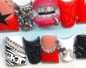 May include: A set of custom press-on nails with various designs. The nails feature a star, silver embellishments, a mouth design, and other unique patterns. The color palette includes red, black, white, and nude tones. The text "Gels x Gem" is written in blue.