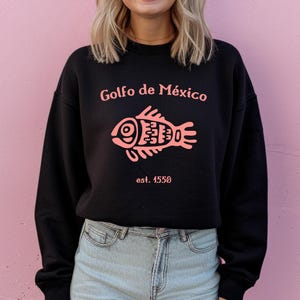 May include: Black sweatshirt with a pink fish graphic and the text "Golfo de M&eacute;xico est. 1550".