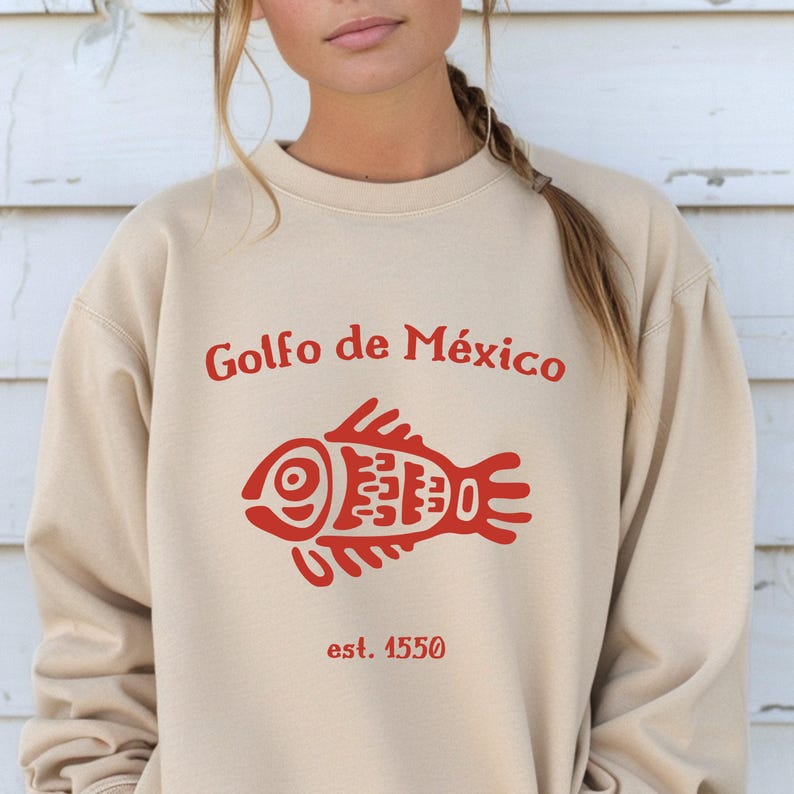 May include: A beige sweatshirt with a red graphic of a fish and the text "Golfo de M&eacute;xico est. 1550".