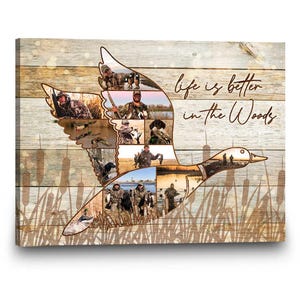 May include: Canvas art print featuring a duck silhouette filled with hunting scenes. The background has a wood grain pattern with the text "life is better in the Woods" in a cursive font. Reeds are at the bottom.