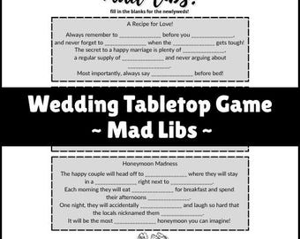 May include: A black and white wedding tabletop game titled "Mad Libs!" with fill-in-the-blank prompts. The game includes sections for "A Recipe for Love!" and "Honeymoon Madness," with text and illustrations of wedding shoes.