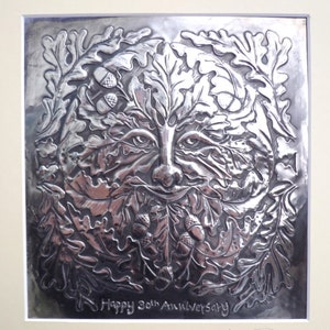 May include: A silver embossed metal plaque with a green man face surrounded by oak leaves and acorns. The plaque reads "Happy 30th Anniversary" and is signed "Jamie Liddiard 2012".