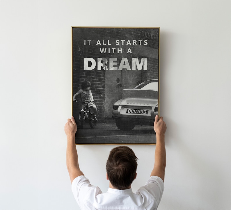May include: Black and white photo print of a child riding a bicycle in front of a classic car with the text "It all starts with a dream" printed on the top of the image.