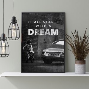 May include: Black and white photo print of a child riding a bicycle in front of a vintage car with the text "It all starts with a dream".