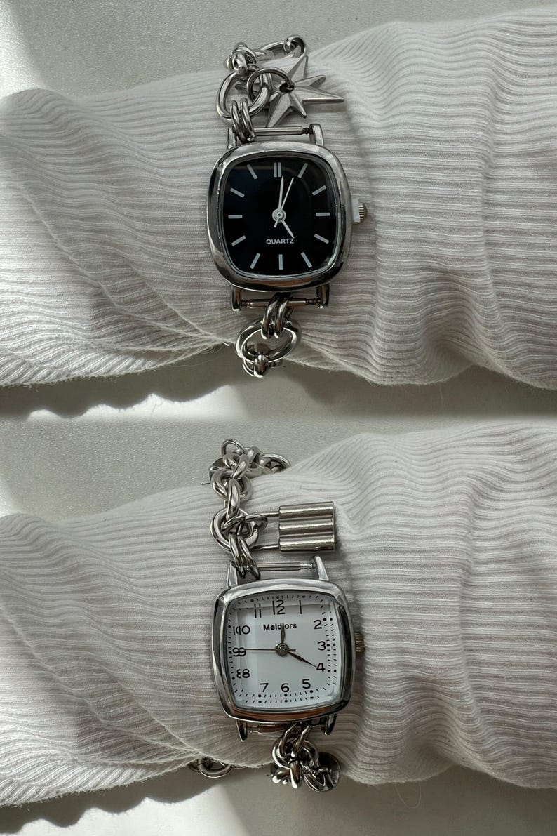 May include: Two silver watches with chain link bands. The top watch has a black face with silver hands and the text "QUARTZ". The bottom watch has a white face with black hands and the text "Meidiors".