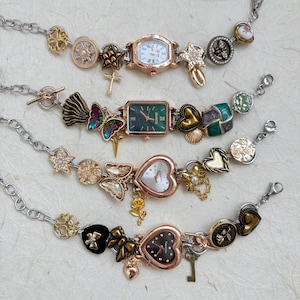 May include: Four vintage-style charm bracelets with watch faces. The watches have different shapes, including rectangular and heart-shaped faces. The bracelets feature various charms, including butterflies, crosses, and keys, in gold, silver, and black.