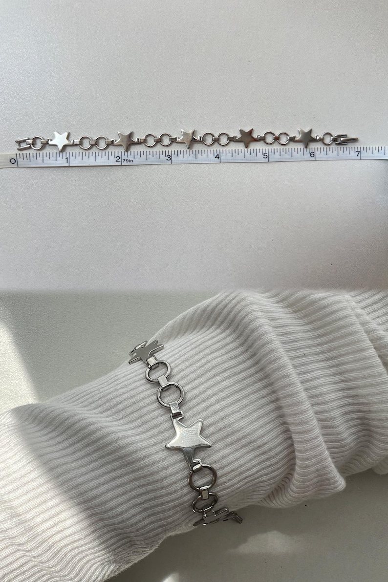 May include: A silver chain bracelet with star-shaped links. The bracelet is approximately 7 inches long.