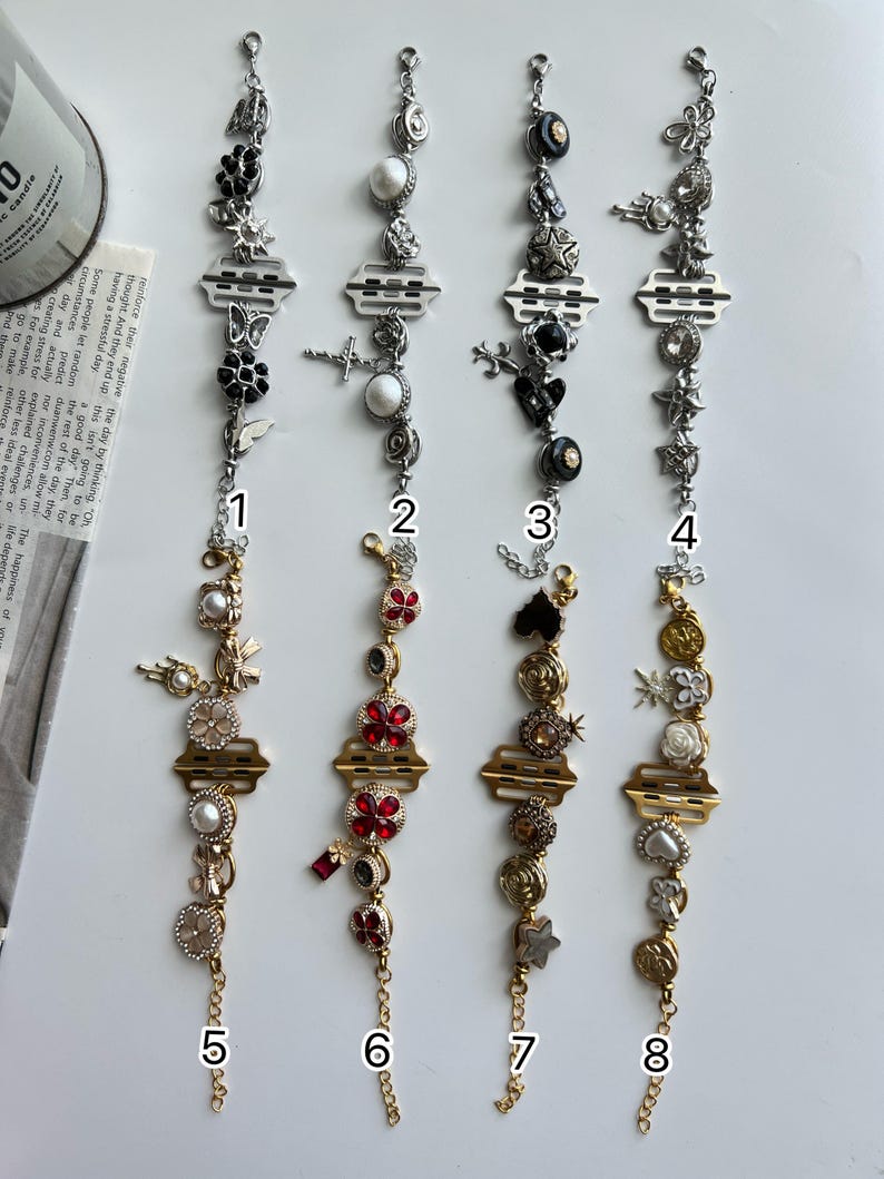 May include: Eight decorative bracelets with various charms, including flowers, crosses, and pearls. The bracelets feature silver and gold tones, with some adorned with black and red accents. Each bracelet has a unique design.