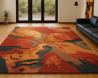 Könnte beinhalten: Ein großer, rechteckiger Teppich mit einem abstrakten Design in Rot-, Orange- und Blautönen. Der Teppich hat ein strukturiertes Muster, das eine visuelle Tiefe erzeugt. Der Teppich liegt auf einem Holzboden in einem Raum mit großen Fenstern.