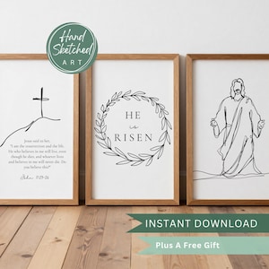 Puede incluir: Tres impresiones artísticas enmarcadas con dibujos lineales minimalistas. Las impresiones presentan una cruz sobre una colina, una corona con las palabras "He is Risen" y una representación de Jesús. Los marcos son de color marrón claro.