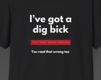 May include: Black t-shirt with the text "I've got a dig bick" in white, with a red banner that reads "YOU THAT READ WRONG" and the text "You read that wrong too" below. The shirt has a meme logo in the bottom right corner.