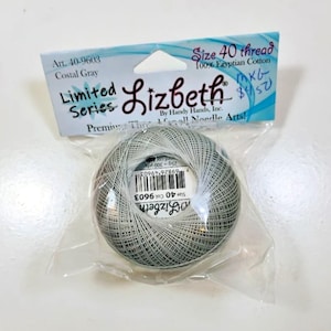 Puede incluir: Un ovillo de hilo Lizbeth de tamaño 40 en color Costal Gray, hecho de 100% algodón egipcio. El hilo está empaquetado en una bolsa de plástico transparente con una etiqueta que indica Art. 40-9603, 25g y 300 yds, incluyendo un código de barras.