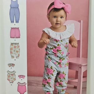 Può includere: Una busta per cartamodello Simplicity S8933 per abbigliamento per bambini, con illustrazioni di una tuta, pantaloncini, pantaloni e fasce per capelli. La copertina mostra un bambino che indossa una tuta a fiori con colletto bianco a balze e fascia rosa.