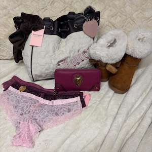May include: A selection of Juicy Couture accessories, featuring a white and black handbag, a pink wallet, brown boots with white fur trim, and lace underwear in pink and burgundy. A pink heart charm is attached to the handbag.