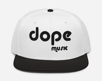 以下が含まれることがあります： 黒文字で「dope music」と書かれた白黒のベースボールキャップ