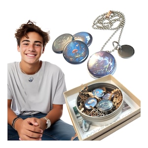 May include: A set of five round, silver-toned pendants with colorful, abstract designs. The pendants are in a small, round, silver tin with brown paper packing material. A silver chain necklace with a silver pendant is also included. The tin has a label that reads "polarifit the next com".