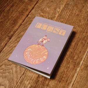 May include: A light purple booklet titled "A creative mind is a perpetual feast issue 5" featuring an illustration of a person riding a horse on a swirling orange planet with the word "FRONTIERS" printed in large letters across the planet surface.