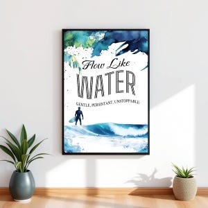 Puede incluir: Impresión artística enmarcada en negro con las palabras "Flow Like Water" y las palabras "Gentle, Persistant, Unstoppable". La impresión presenta un diseño de acuarela de una ola y un surfista. La impresión se muestra en una pared blanca.