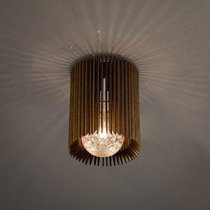 May include: A wooden ceiling light fixture with a clear glass globe and a warm light emanating from it.