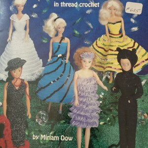 Peut inclure: Une brochure de modèles de crochet pour réaliser des costumes de poupée. La couverture présente cinq poupées portant différentes tenues au crochet, dont une robe noire, une robe bleue à rayures noires, une robe violette, une robe jaune à rayures rouges et un costume de chat noir. Le titre de la brochure est "Fashion Doll Costume Party in thread crochet" et l'auteur est Miriam Dow.
