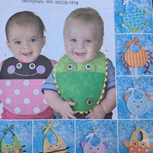 May include: Simplicity sewing pattern number 2468 for making baby bibs. The pattern includes instructions for making a variety of bibs with different animal designs, including a turtle, crab, bear, bee, and owl. The pattern also includes instructions for making a bib with a frog design. The pattern is for one size.