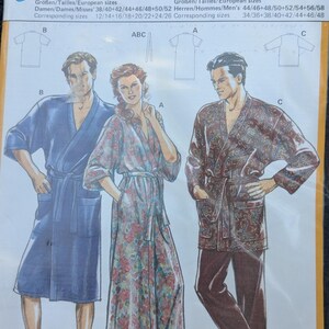May include: A sewing pattern for a robe with the title "Super-Easy" and the number 5223. The pattern includes three different styles of robes, one with a floral print, one with a solid blue color, and one with a paisley print. The pattern is for sizes 38-58 for women and 44-58 for men.