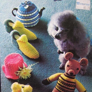 May include: A knitting pattern booklet featuring a variety of knitted items, including a teapot cosy, slippers, a hat, a teddy bear, and a poodle. The booklet is titled "Bazaar Novelties and Gifts by Beehive" and is from Patons.