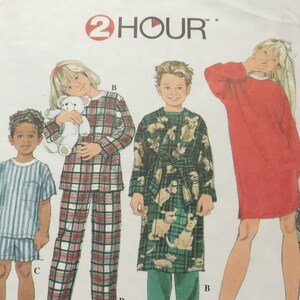 May include: A sewing pattern for children's pajamas and a robe. The pattern includes three different designs: a plaid pajama set, a robe with a dog print, and a solid red nightgown. The pattern is from Simplicity and is labeled "2 HOUR".