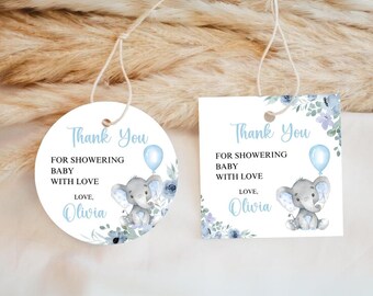May include: Two baby shower gift tags. One is round, the other square. Both have the text "Thank You" and "For Showering Baby With Love, Love, Olivia". Each tag features a gray elephant holding a blue balloon, surrounded by blue floral accents.