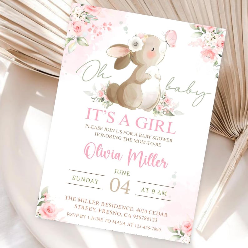 Puede incluir: Una invitaci&oacute;n a un baby shower con un dise&ntilde;o de acuarela. La invitaci&oacute;n presenta un conejito marr&oacute;n con una corona floral y una mariposa rosa. El texto incluye "Oh baby", "It's a Girl" y los detalles del evento.