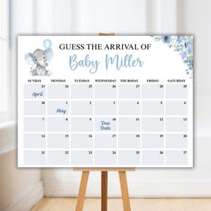 Könnte beinhalten: Ein Babyparty-Kalender mit dem Text "Erraten Sie die Ankunft von Baby Miller". Der Kalender zeigt einen blauen Elefanten mit einem Ballon, Blumenschmuck und ein Kalendarium mit dem markierten Fälligkeitsdatum. Der Kalender wird auf einer Holzstaffelei angezeigt.