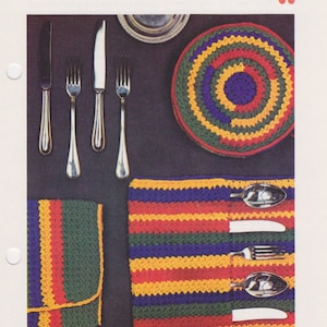 May include: Image of a page from a vintage craft book titled "BAZAAR BESTSELLERS" featuring silverware and plate holders. The image showcases crocheted placemats and holders in vibrant colors, alongside silverware.