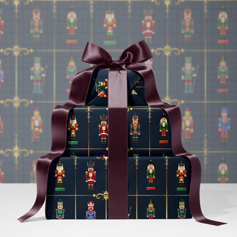 May include: A stack of wrapped gifts with a dark blue background featuring a repeating pattern of toy soldiers in various colors. The gifts are tied with a wide, dark burgundy ribbon and bow, creating a festive holiday presentation.