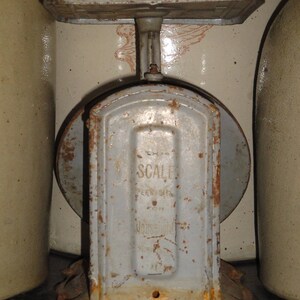 May include: A vintage, rusty, gray metal scale with the words "The Scale" and "Pennsylvania" printed on the front.
