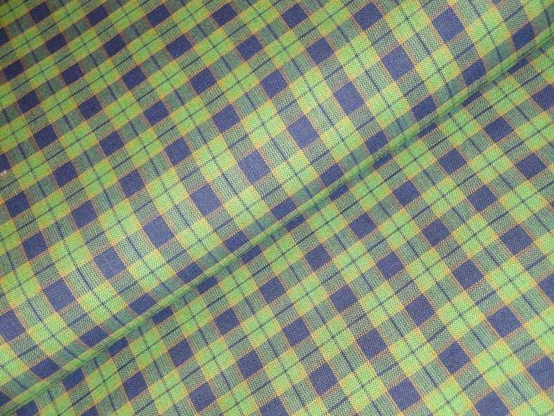 May include: Green and blue plaid fabric with a subtle yellow stripe. The fabric is folded in half, showing the pattern on both sides.