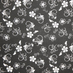 May include: Black fabric with a white floral pattern. The pattern features small flowers with swirling vines.