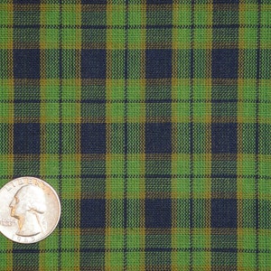 May include: Green, black, and gold plaid fabric with a US quarter for scale.