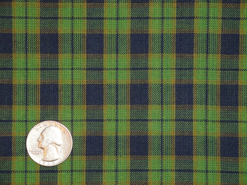 May include: Green, black, and gold plaid fabric with a US quarter for scale.