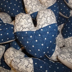 May include: A collection of blue and white quilted fabric squares with a variety of patterns. The fabric squares are arranged in a random pattern and are all sewn together.