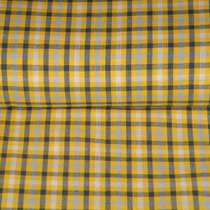 May include: Yellow and black checkered fabric with a white stripe. The fabric is folded in half.
