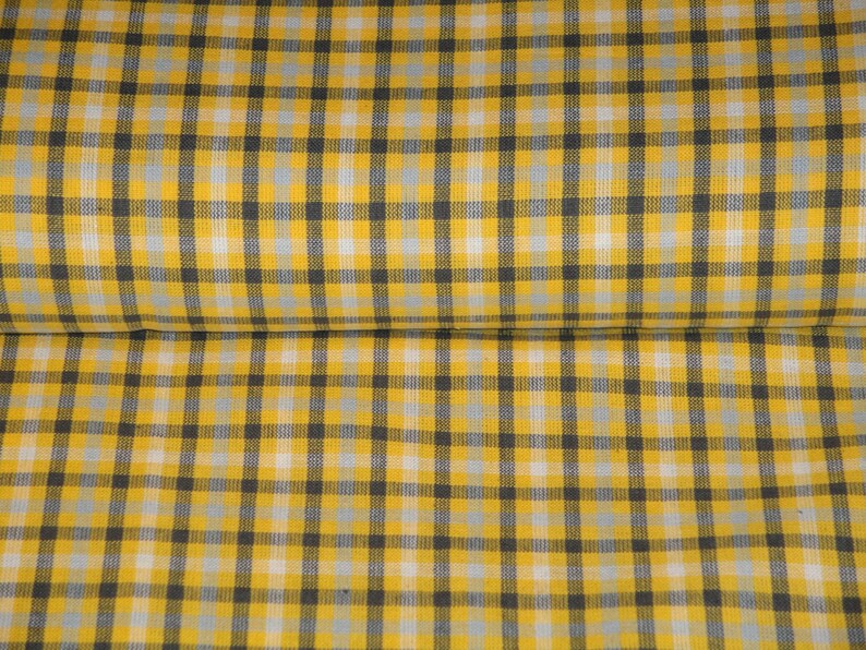 May include: Yellow and black checkered fabric with a white stripe. The fabric is folded in half.