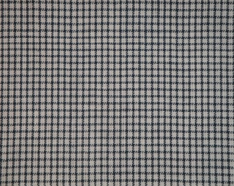 May include: A close-up of a white fabric with a black and white checkered pattern.