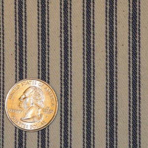 Pode incluir: Close-up de um tecido bege com finas listras azul-escuro. Uma moeda de 25 centavos de d&oacute;lar americano &eacute; colocada no tecido para escala.