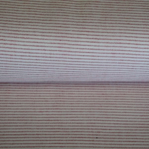 May include: Close-up of a fabric with a repeating pattern of thin, horizontal red stripes on a white background. The fabric is folded, showing the pattern on both the top and bottom layers. The stripes are evenly spaced.