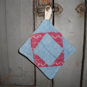 May include: A blue and red quilted pot holder with a white loop for hanging.