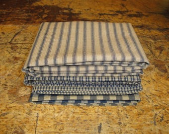 May include: A stack of fabric swatches in various blue and beige striped and checkered patterns.