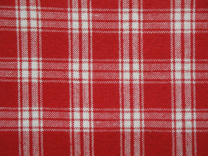 May include: Close-up of a red and white plaid fabric. The fabric has a woven texture with a classic grid pattern. The red color is vibrant, and the white lines create a contrasting design.
