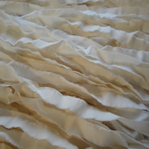 May include: A close-up of a pile of white fabric strips, creating a textured background.