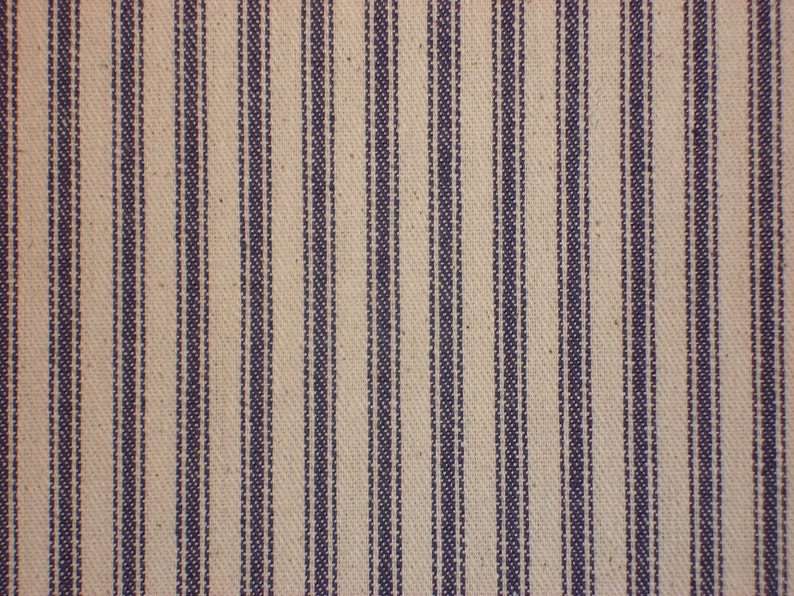 Pode incluir: Um close-up de um tecido com um padr&atilde;o listrado. O tecido &eacute; de cor bege claro com listras finas de cor azul escuro.