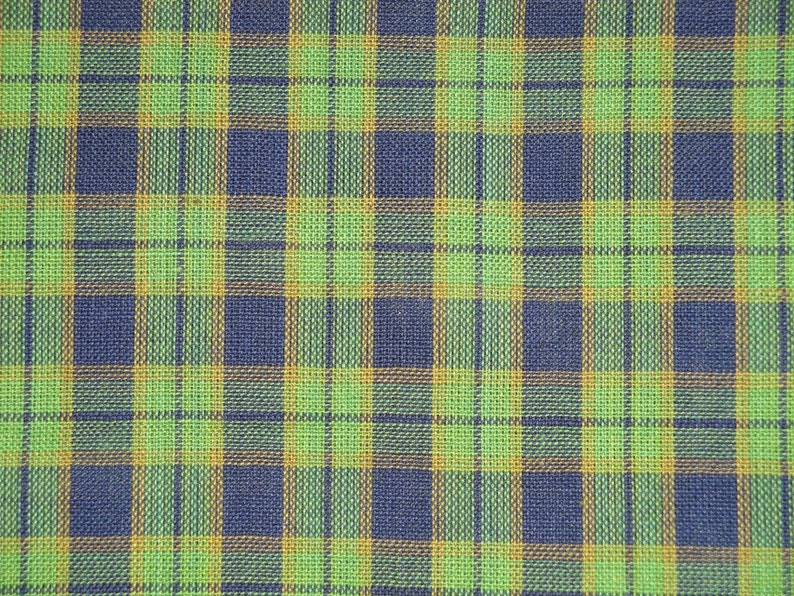 May include: A green, blue, and orange plaid fabric with a woven texture.